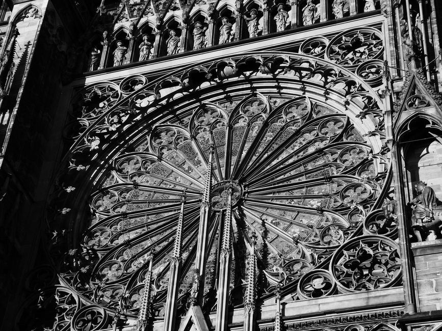 Close-up of the ornamental Gothic architecture of Strasbourg Cathedral's rose window.