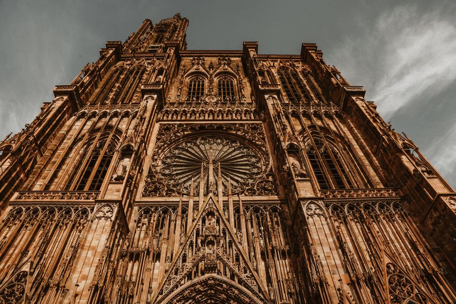 Striking low-angle view of Strasbourg Cathedral showcasing its Gothic architectural details and rose window.