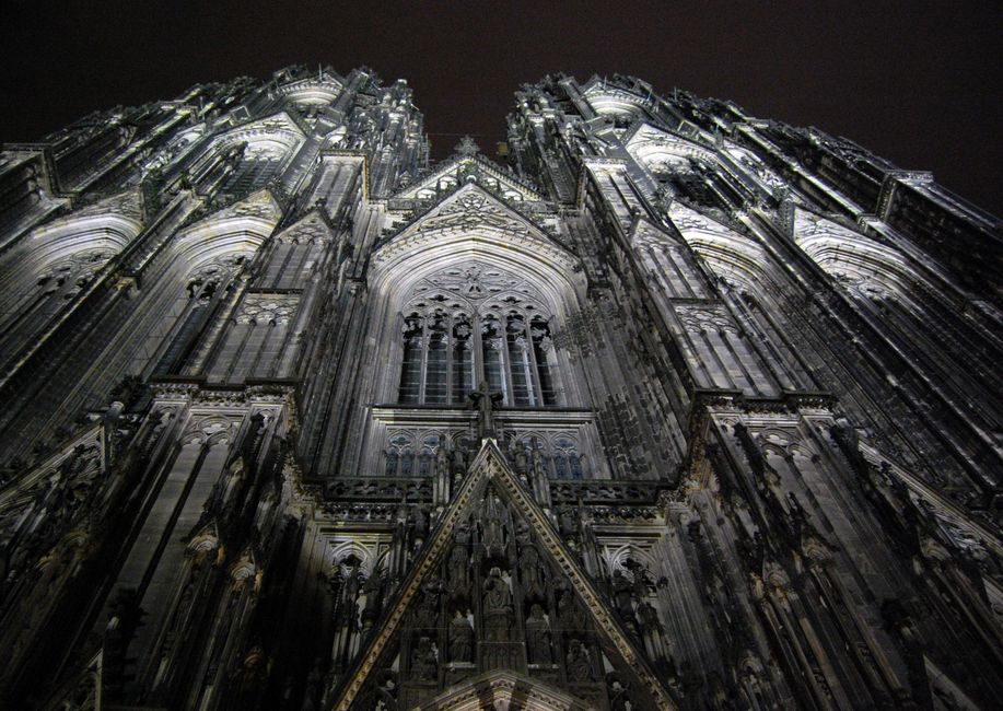Striking architectural view of Cologne Cathedral at night showcasing Gothic design details.